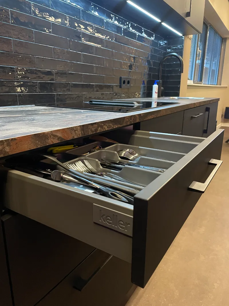 Een keuken op het werk met een la vol keukengerei.