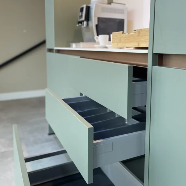 Open lades in een strak keukenkastje met een koffiezetapparaat en kopjes, elegant gerangschikt op het aanrecht. - kitchen at work